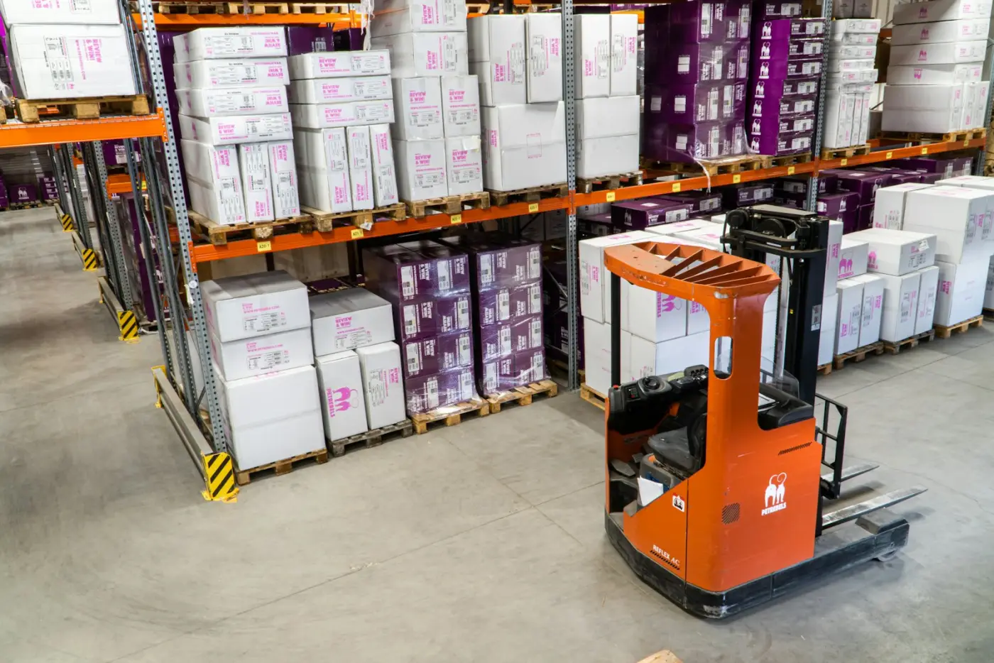 Palletised stock and a forklift on a warehouse floor