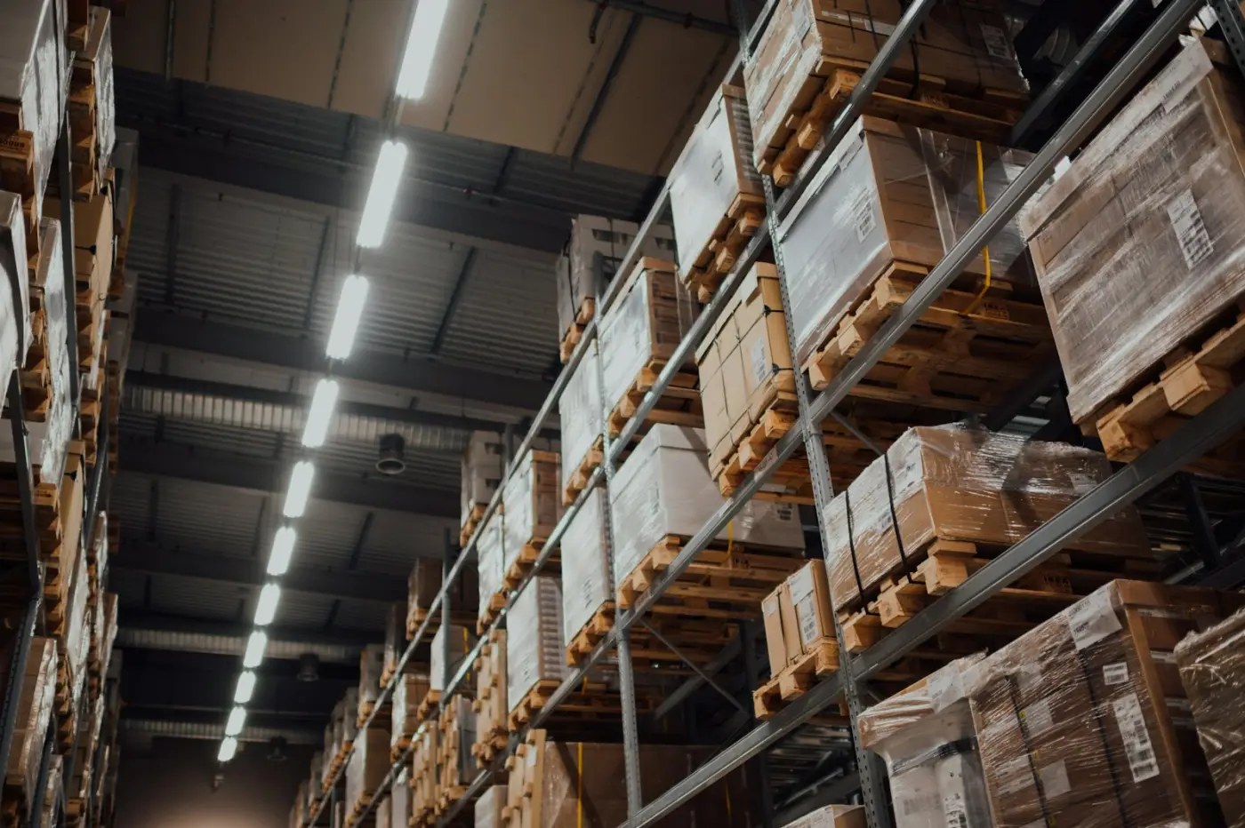 Pallet racking filled with wrapped cartons in a warehouse aisle